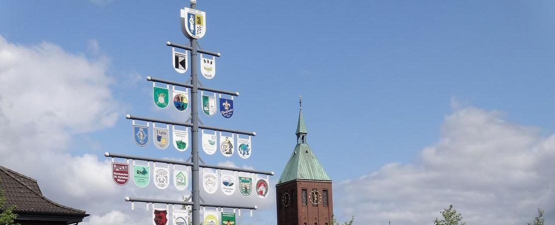 Weeze Ortsplatz mit Vereinsbaum mit unterschiedlichen Wappen